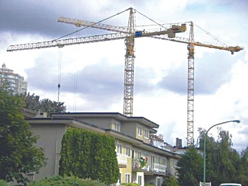 Two cranes are in front of a building.